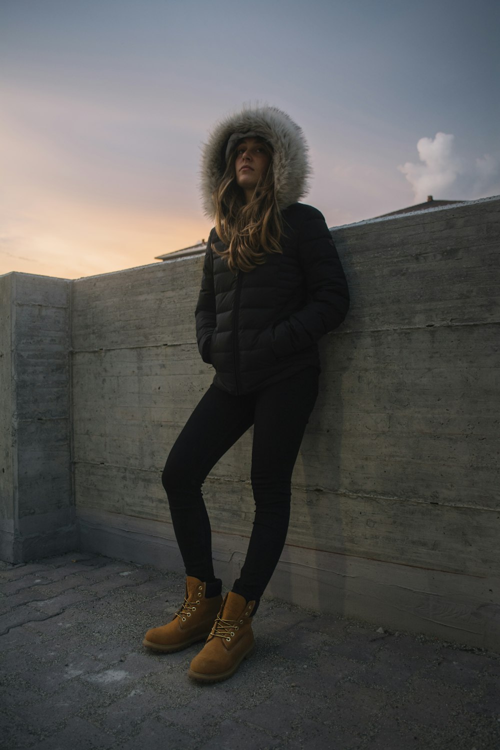 Femme appuyée sur un mur de béton