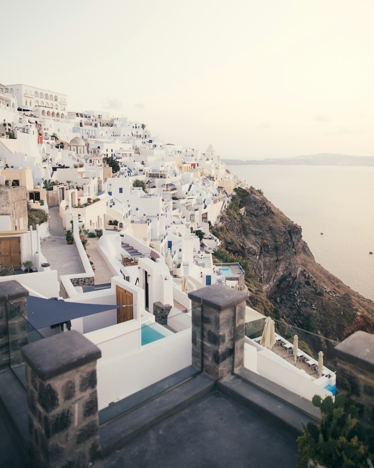 White buildings of Santorini Greece cascading down cliffs overlooking the blue Aegean Sea