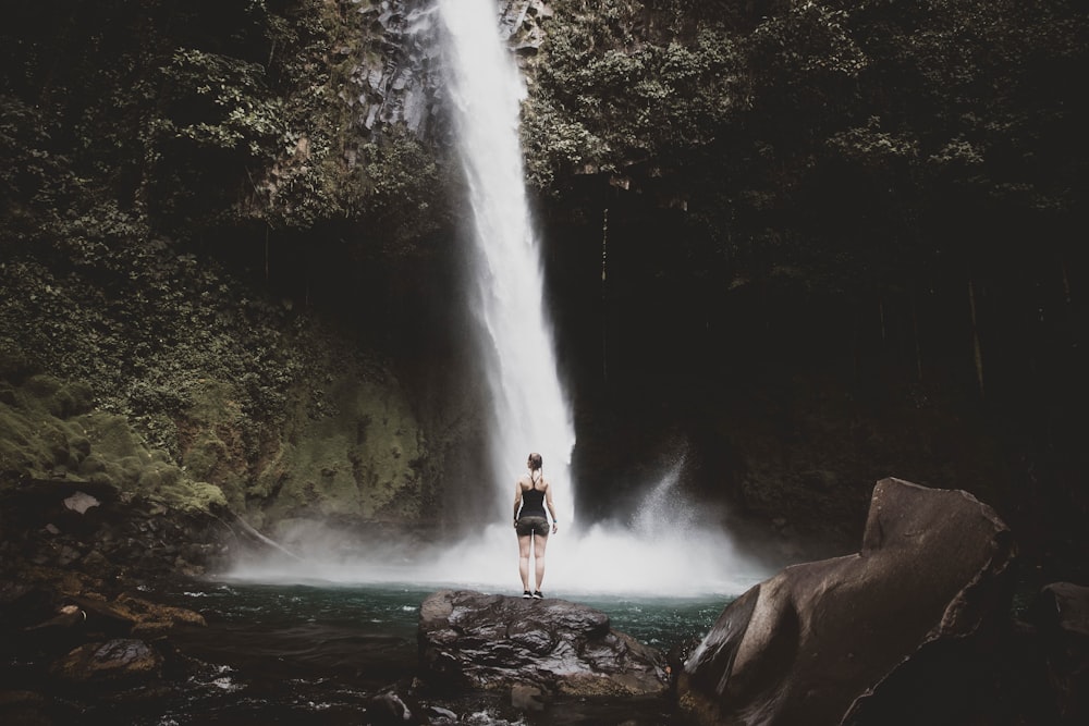 woman standing infront of waterfall
