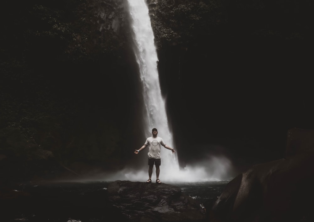 man standing near waterfalls