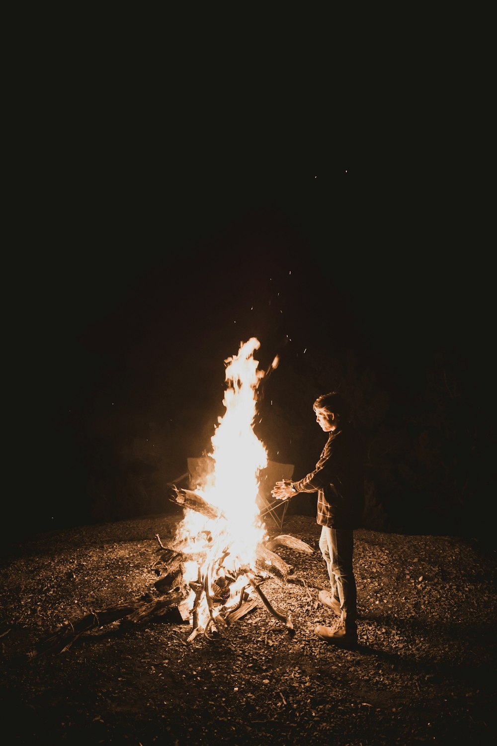 Mann steht in der Nähe der Feuerstelle