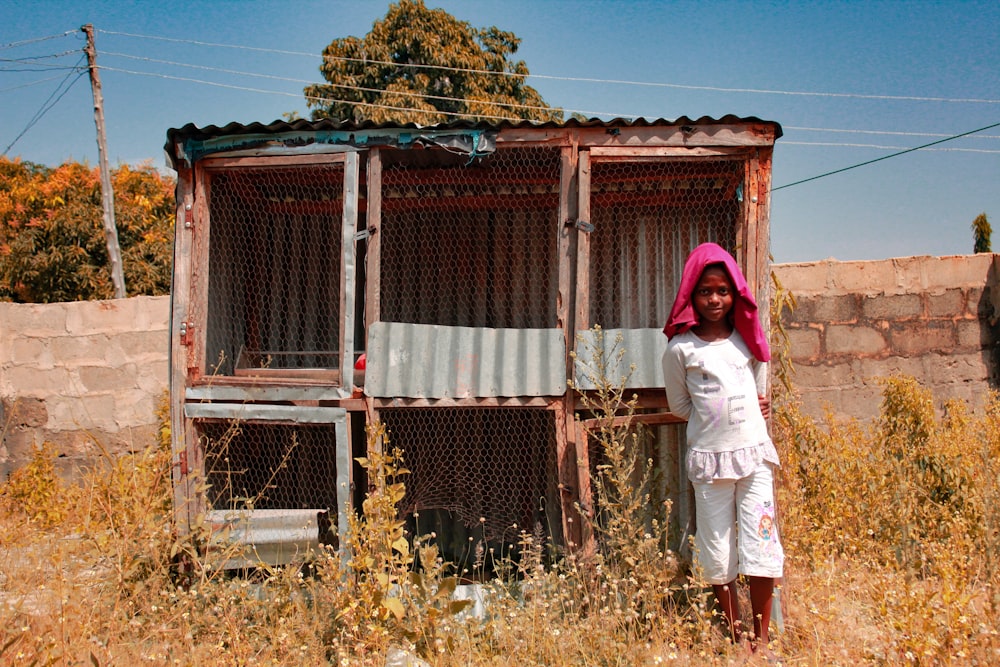 girl standing beside bird cage