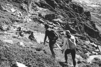 A pair of friends wearing Earthpeak caps while hiking on a forest trail.