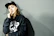 Close-up of a young urban customer wearing a sleek black nokto hoodie against a dark, minimalist background.