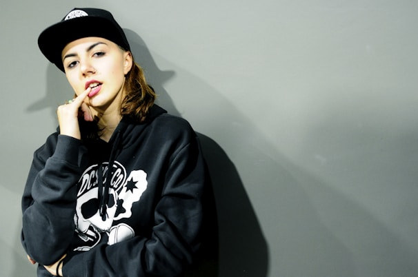 Model wearing a minimalist blvkhvnd hoodie against an urban graffiti backdrop.