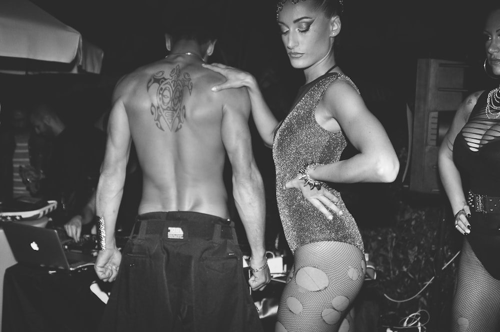 topless man beside woman posing on stage