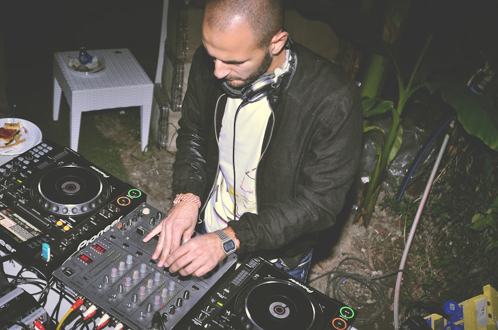 man using DJ audio mixer at night
