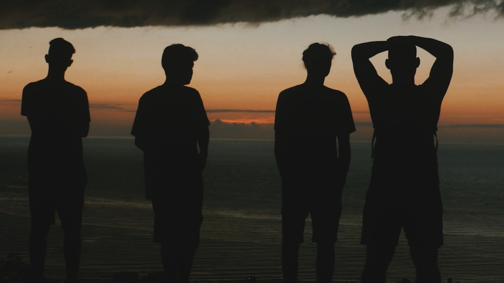 silhouette of four men at the beach