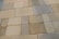 A series of rectangular stone tiles with varying shades of beige, gray, and brown create a patchwork pattern. The texture of the stones is slightly rough, indicating a natural material often used for outdoor flooring or walkways.