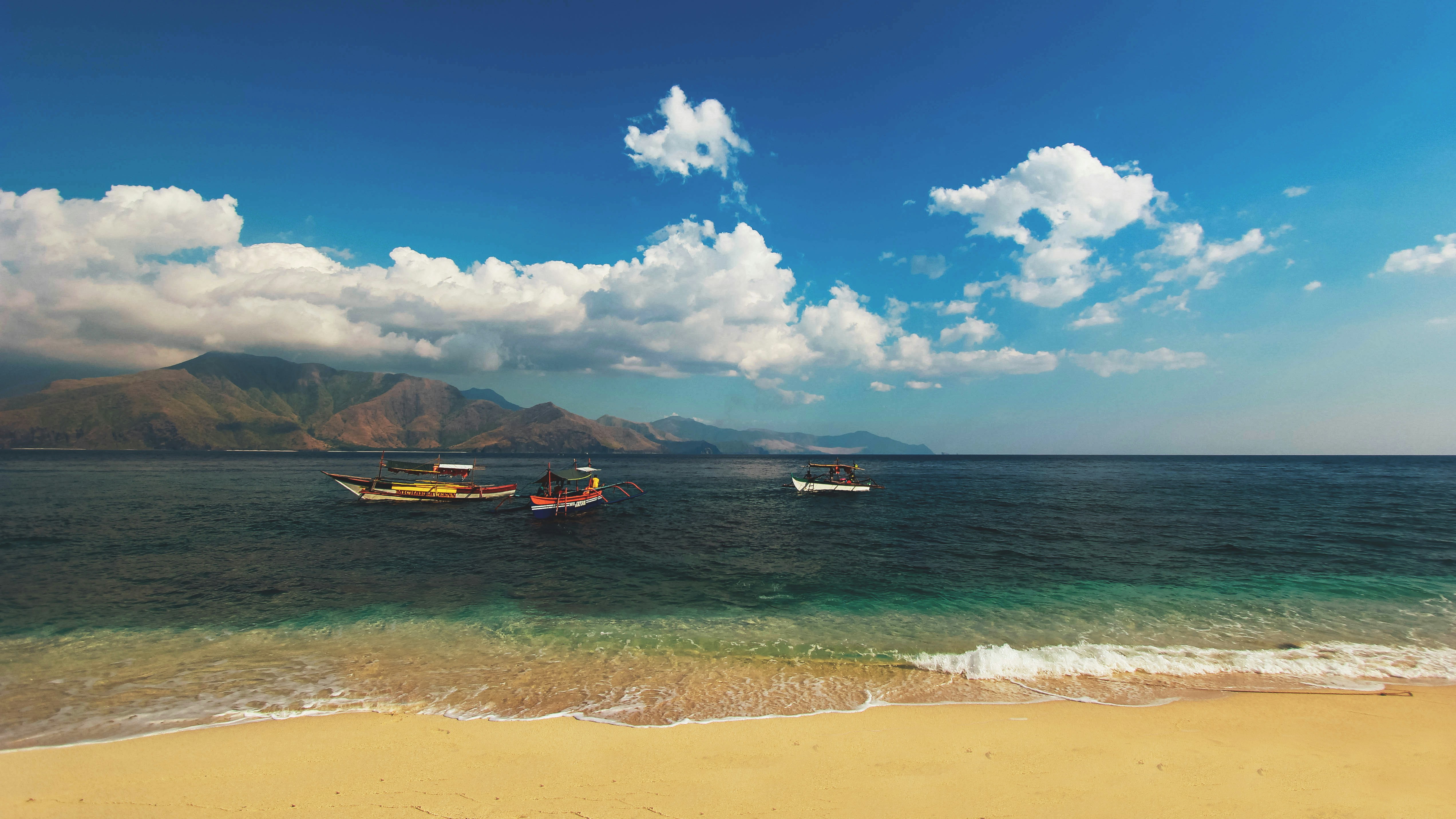 brown, red, and white rowboats on body of water near shore during daytime