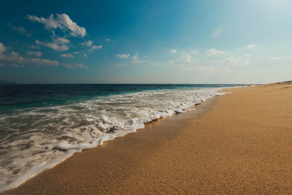 fotografia de natureza da costa e areia marrom durante o dia