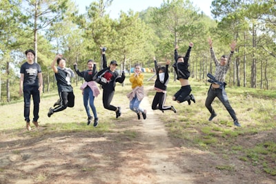 A joyful group photo of campers smiling with the forest backdrop