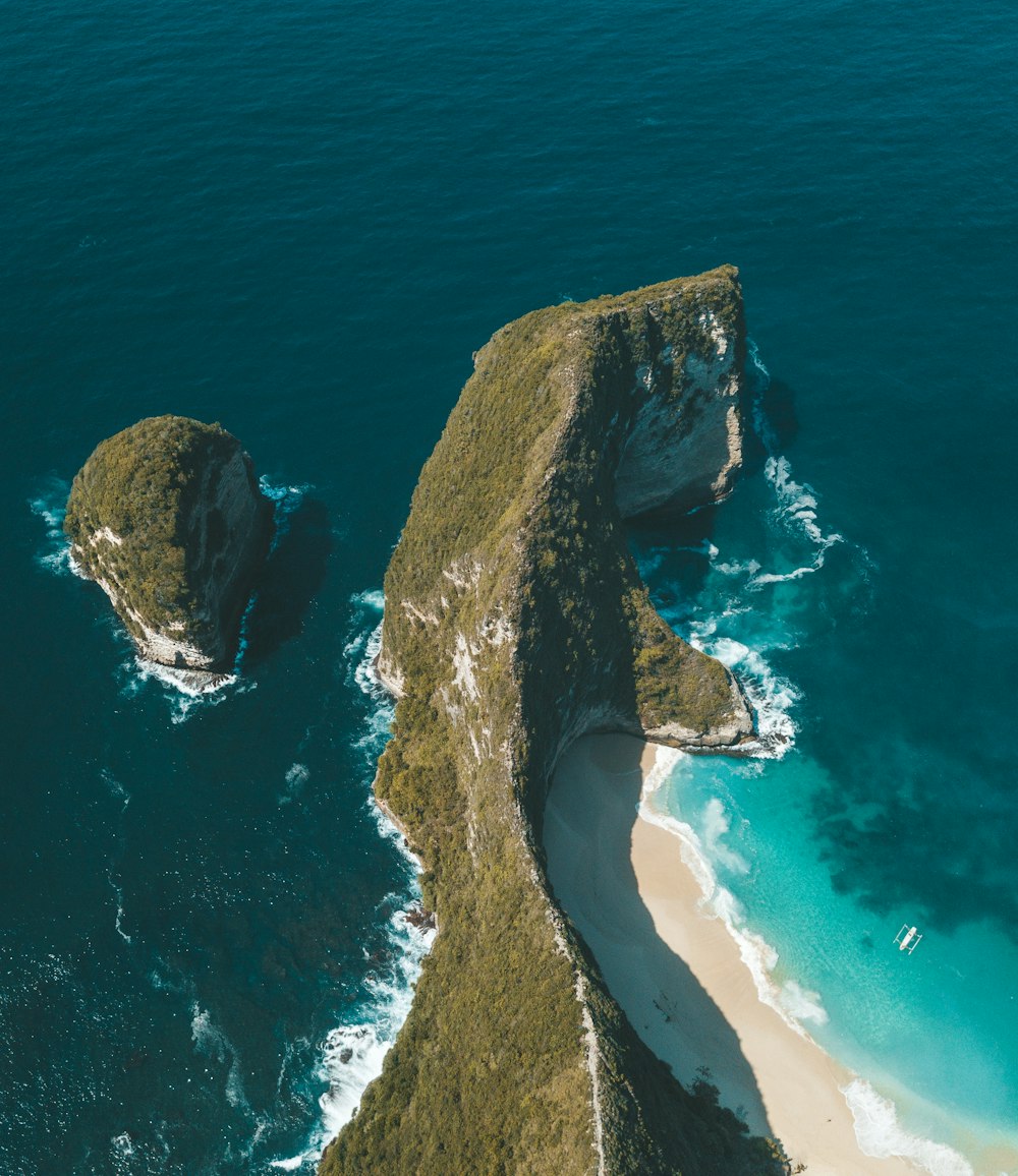 green rocky cliff island with islet on beside