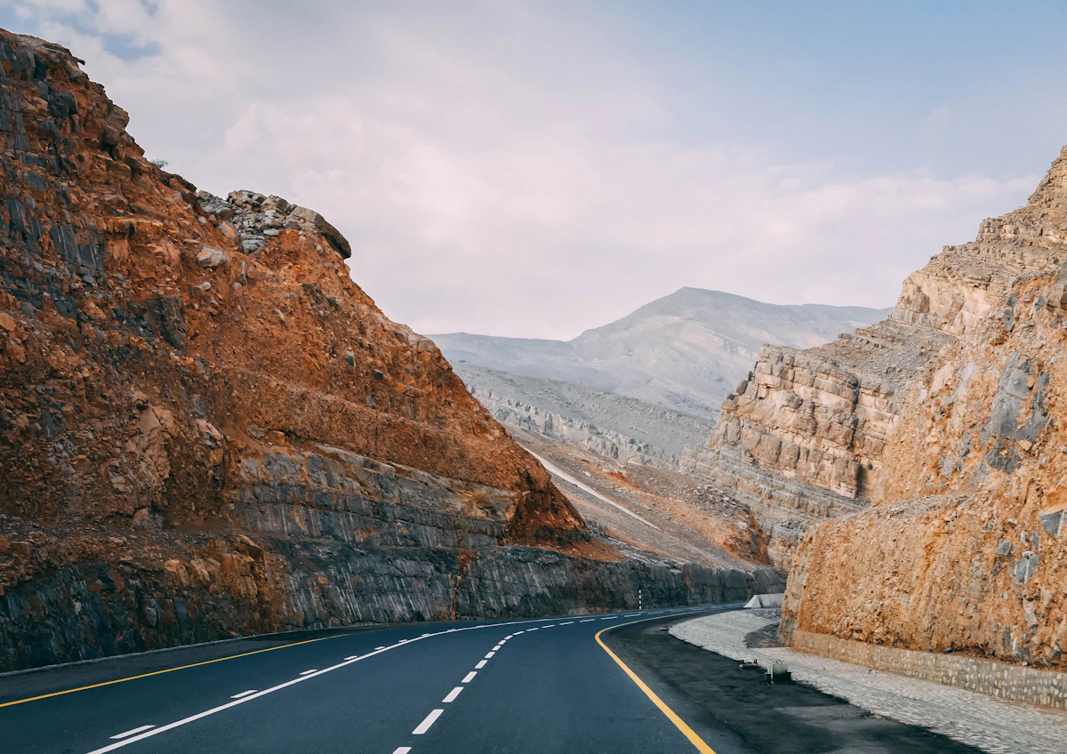 A winding road between brown rocky mountains