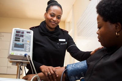 woman having blood pressure monitor nurse teams background