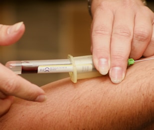 person injecting syringe