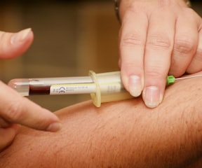 person injecting syringe