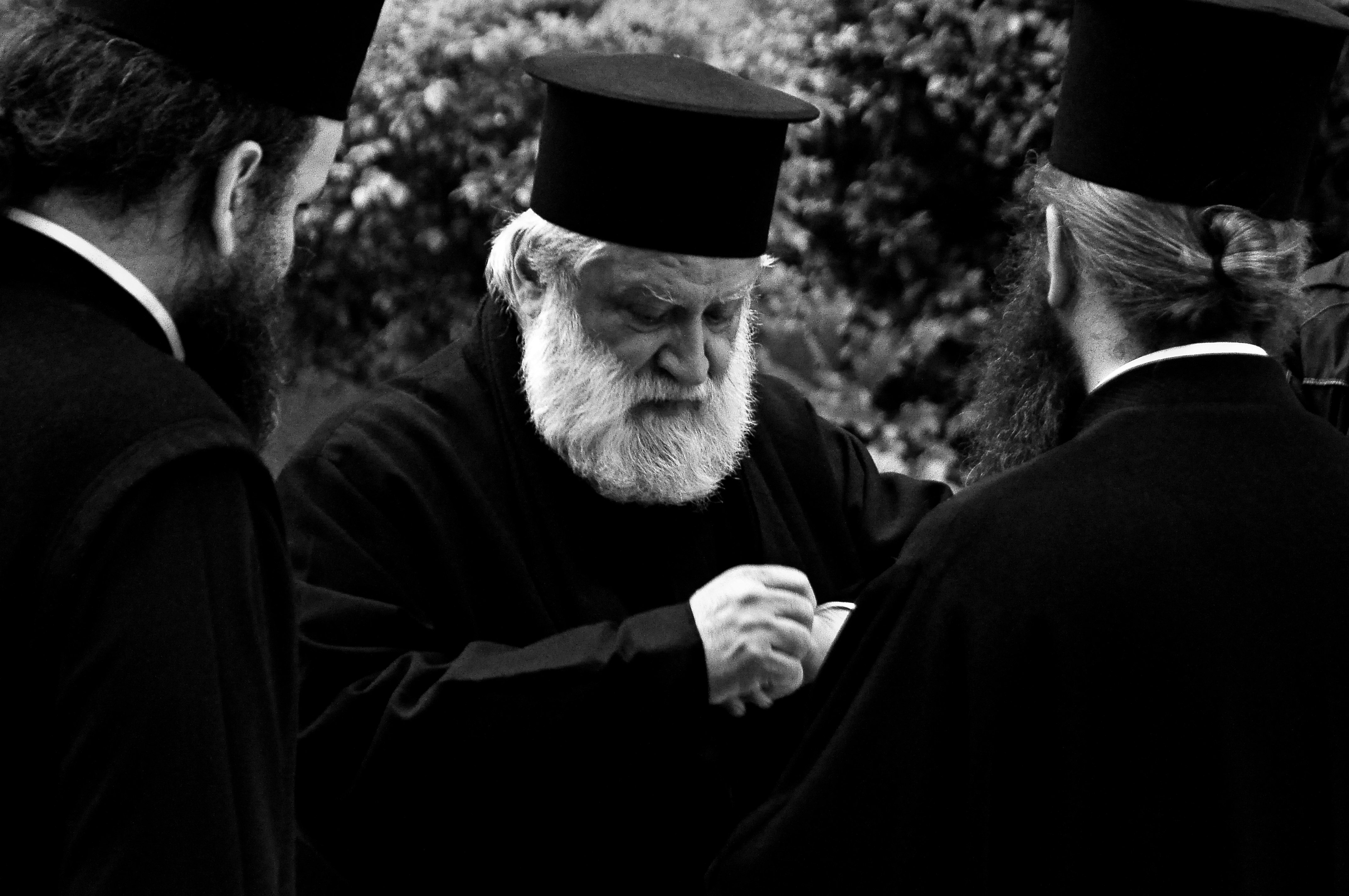 grayscale photography of three men wearing black robes and hats