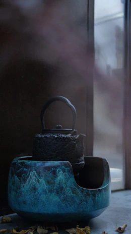 Artisan stoneware teapot with a rich cobalt glaze, steam gently rising in a calm morning setting.