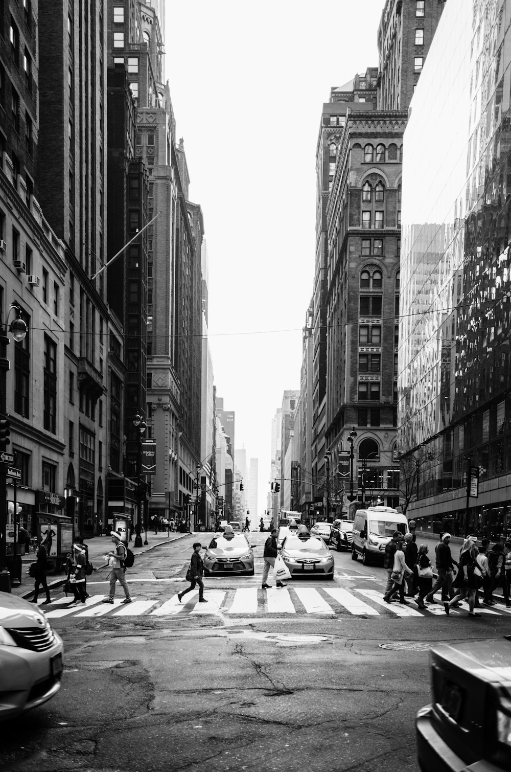Foto en escala de grises de personas cruzando la calle