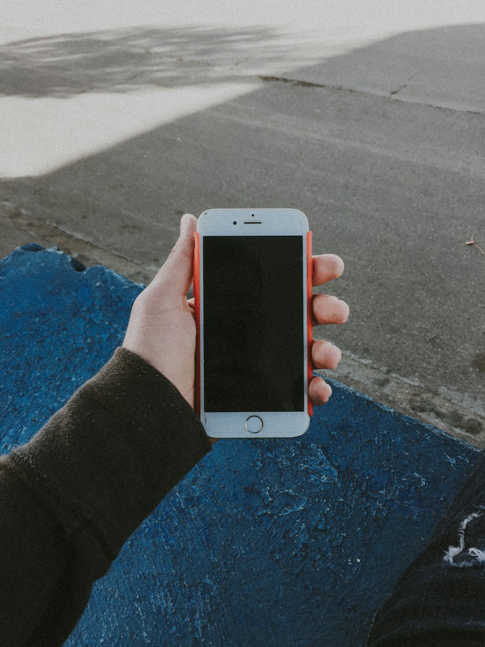 Person mit ausgeschaltetem goldenem iPhone 6