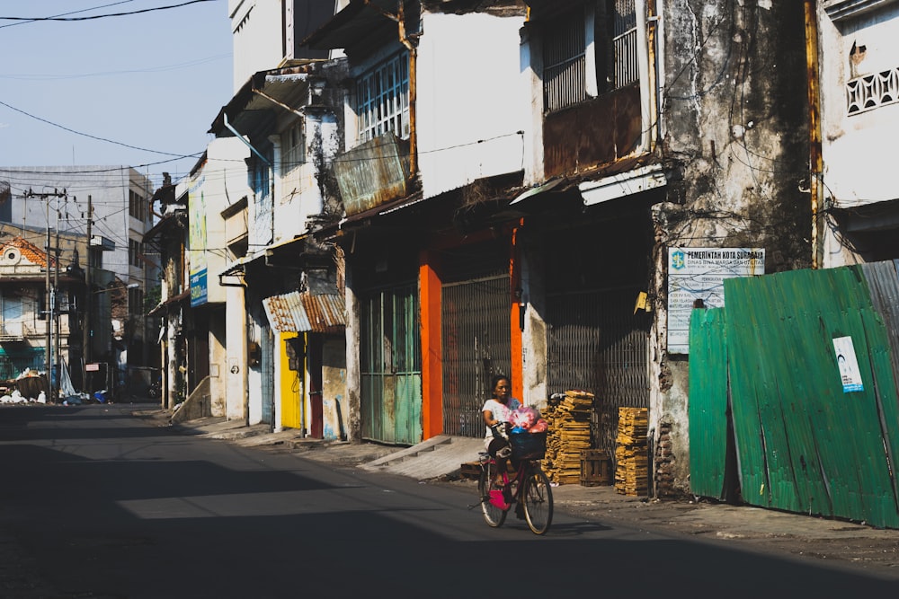 woman riding bicycle near houses