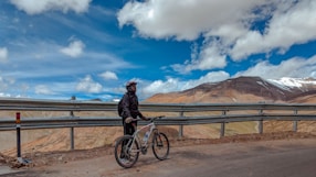 cyclist stop at the road to look at the sky