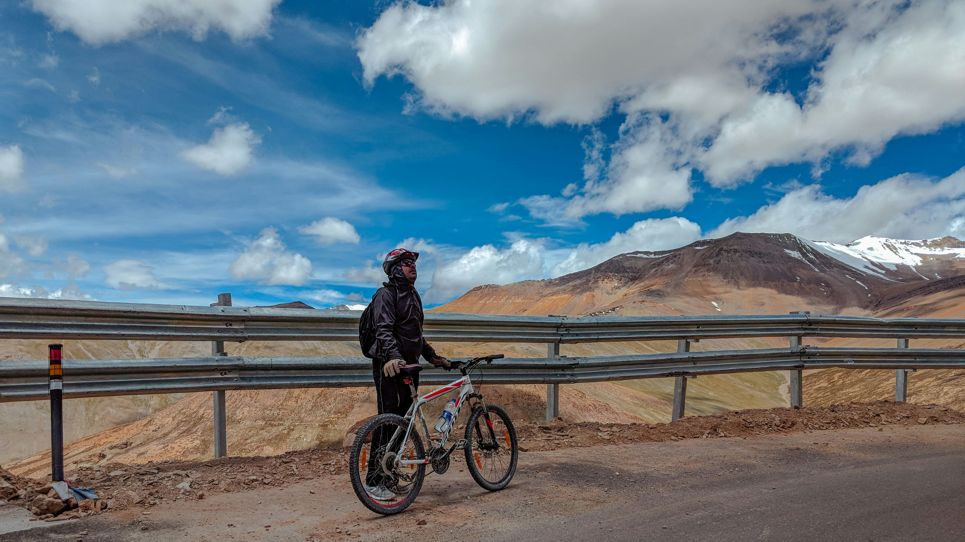 Ciclista deteniéndose en la carretera para mirar al cielo
