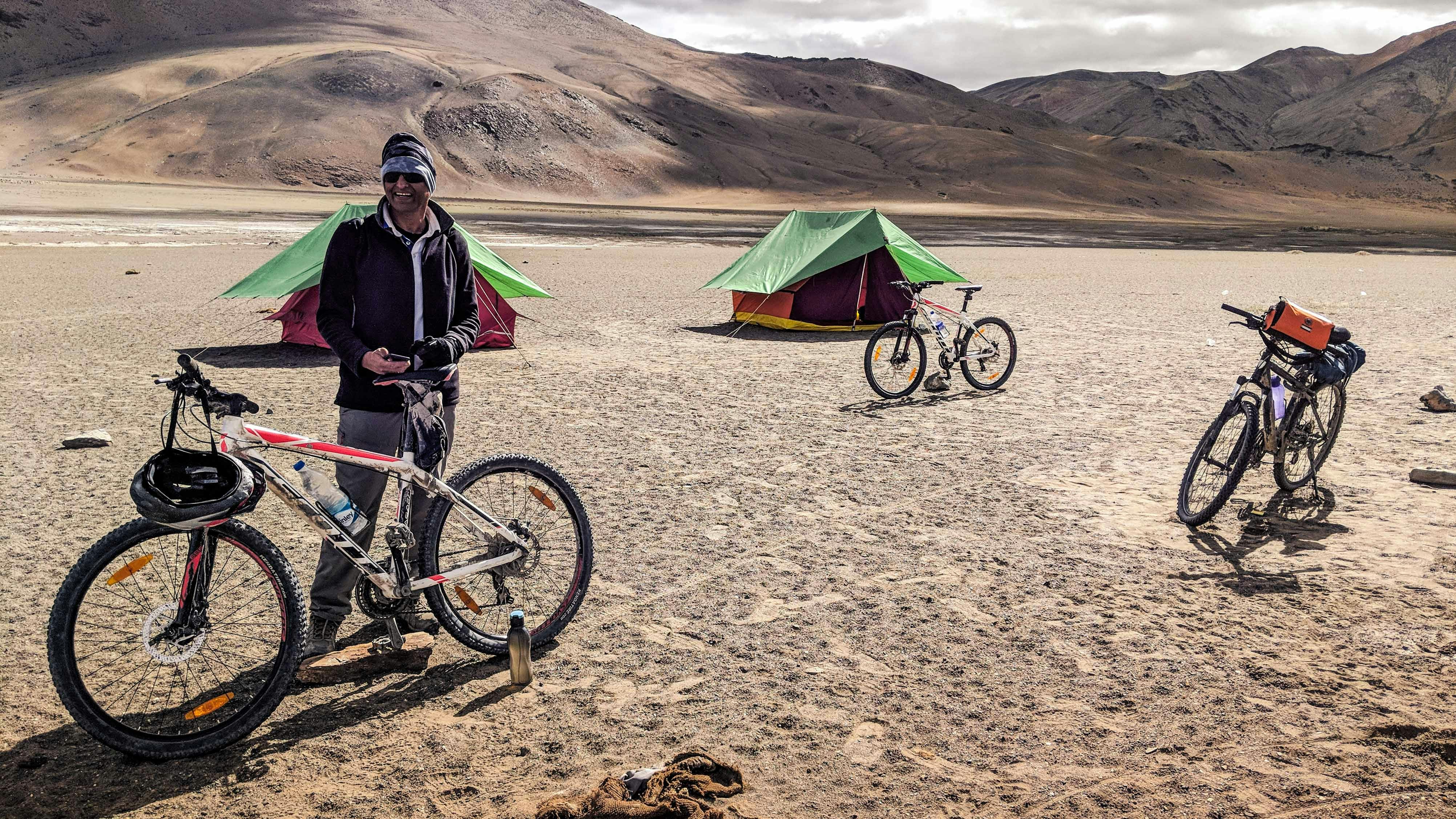 man with bicycle near tent during daytime