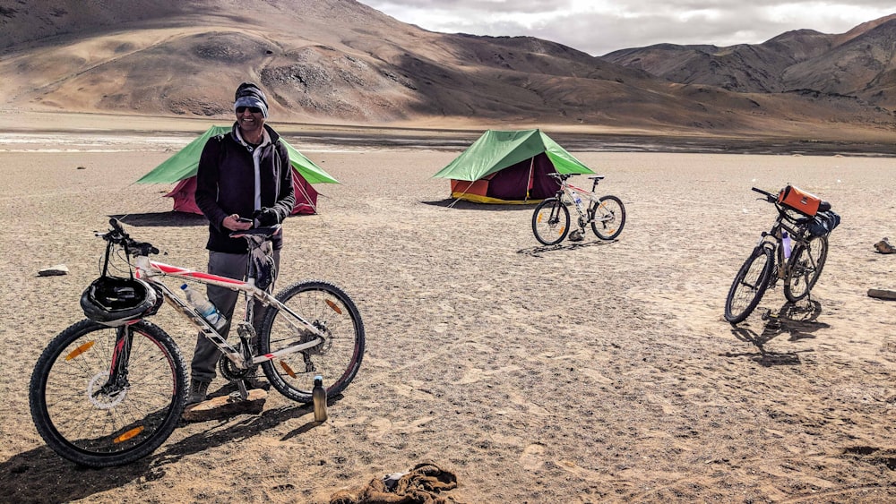 man with bicycle near tent during daytime