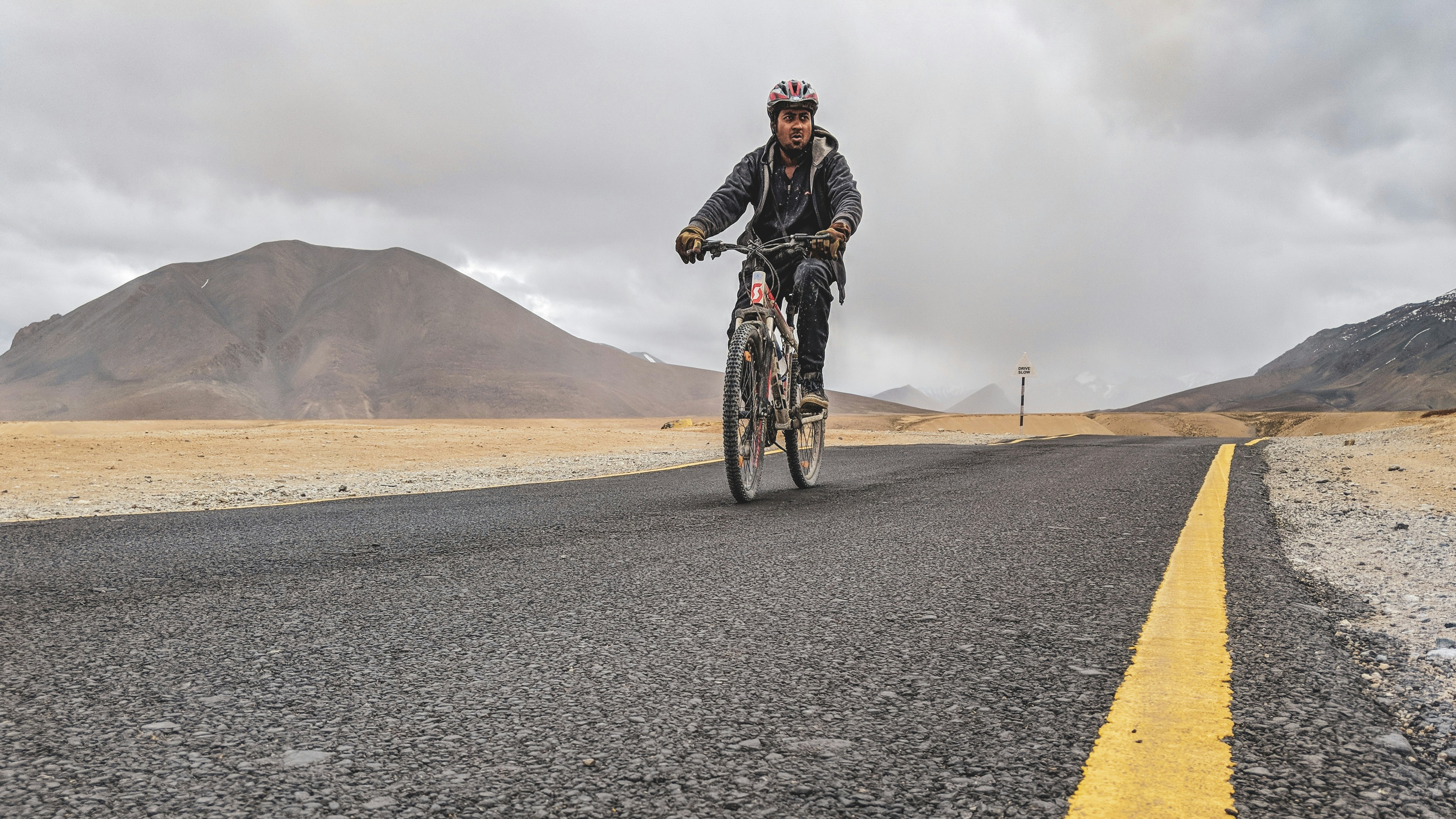 man riding bicycle on asphalt road during daytime