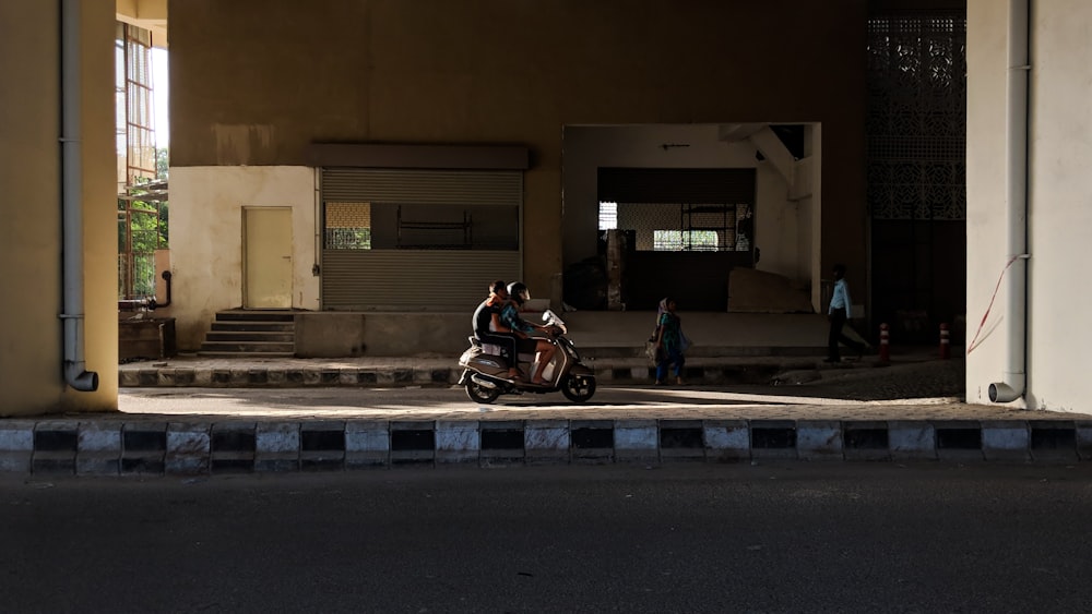 two person riding on motor scooter