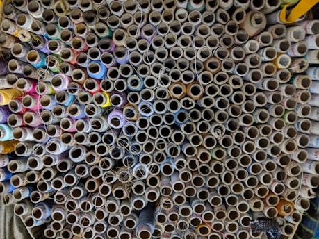 A close-up of colorful yarn spools arranged neatly on a wooden table.