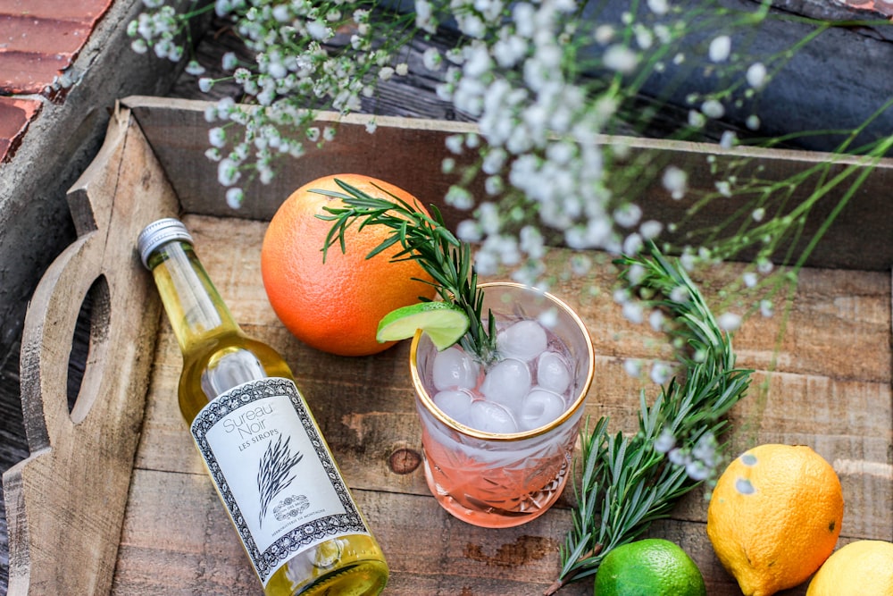 orange fruit beside bottle of drink