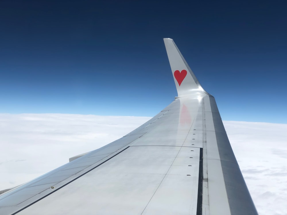 airplane's left wing at high altitude during daytime