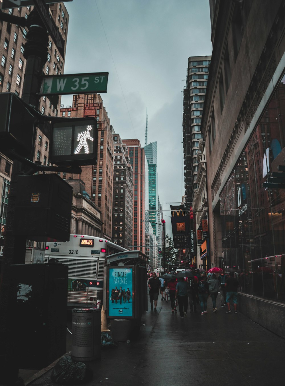 people with umbrellas walking at W35 street during daytime