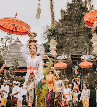 women in traditional dress with flower pots on head during daytime