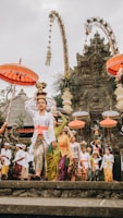women in traditional dress with flower pots on head during daytime