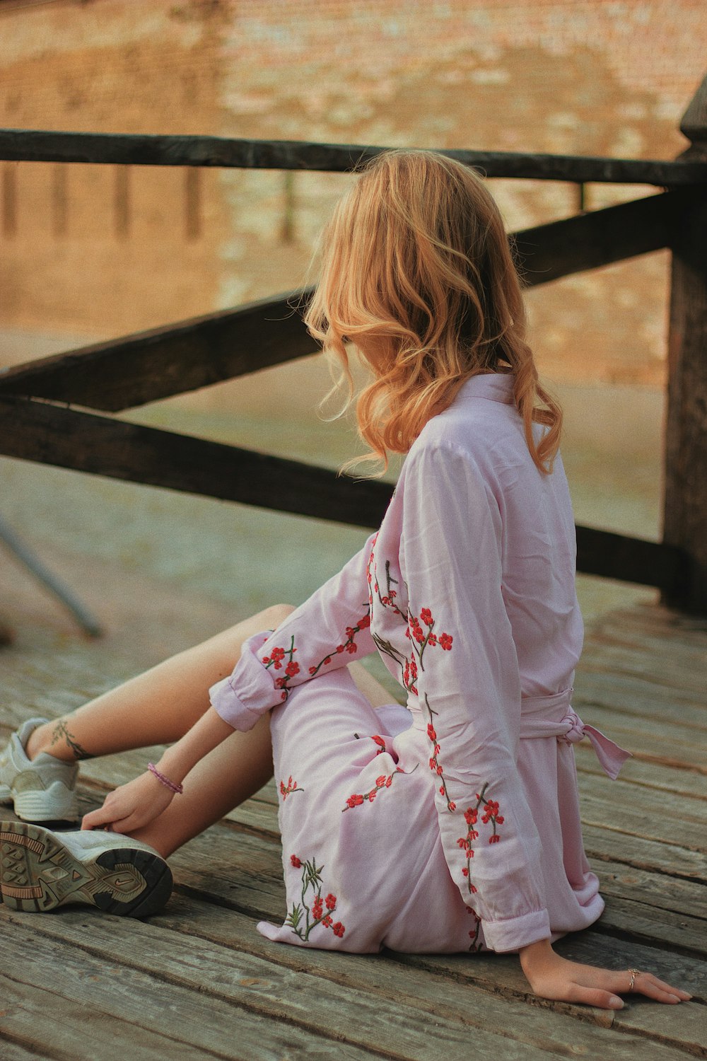 woman sitting on dock near body og water