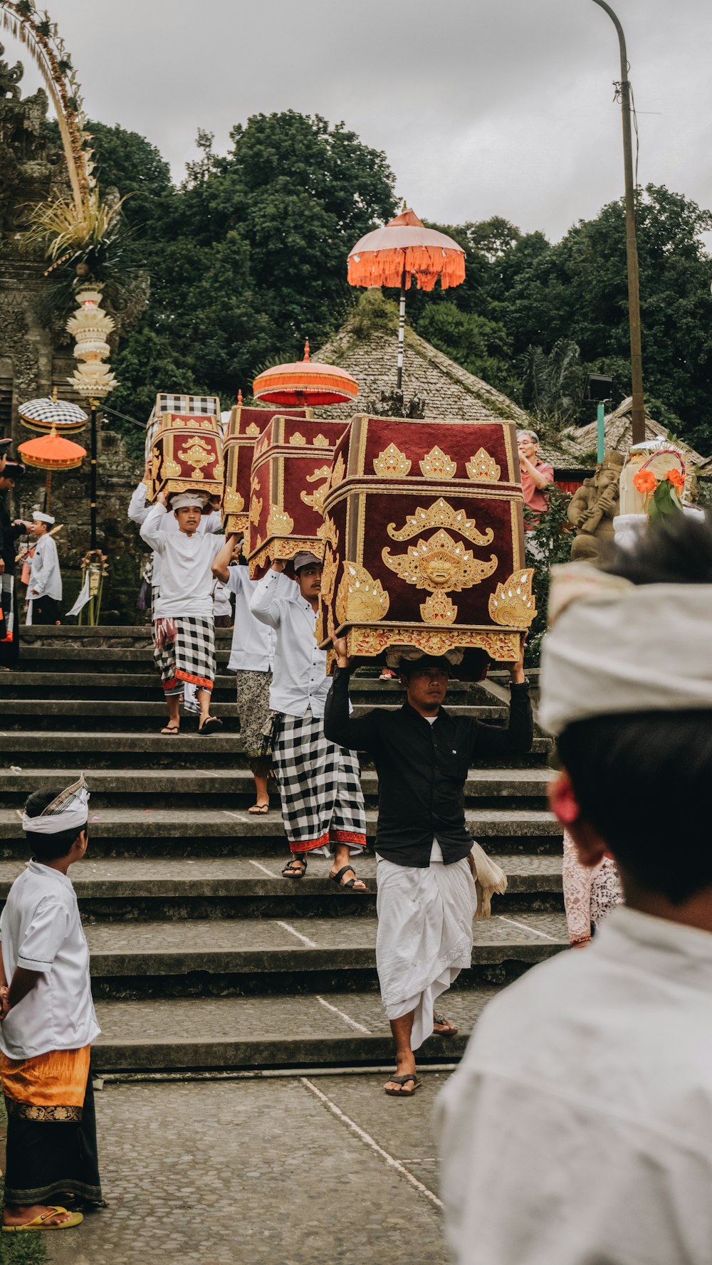 men carrying red and gold boxes