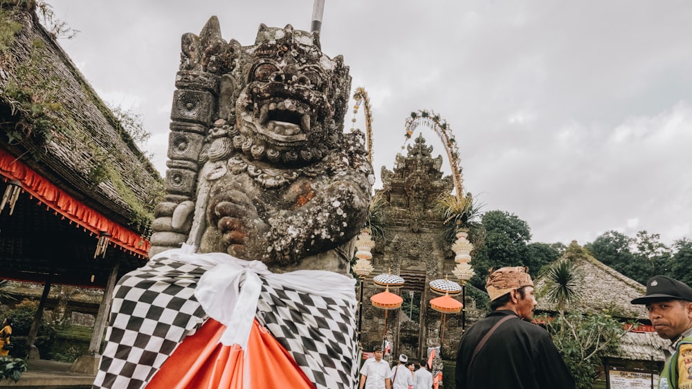 people standing with concrete dragon statue background