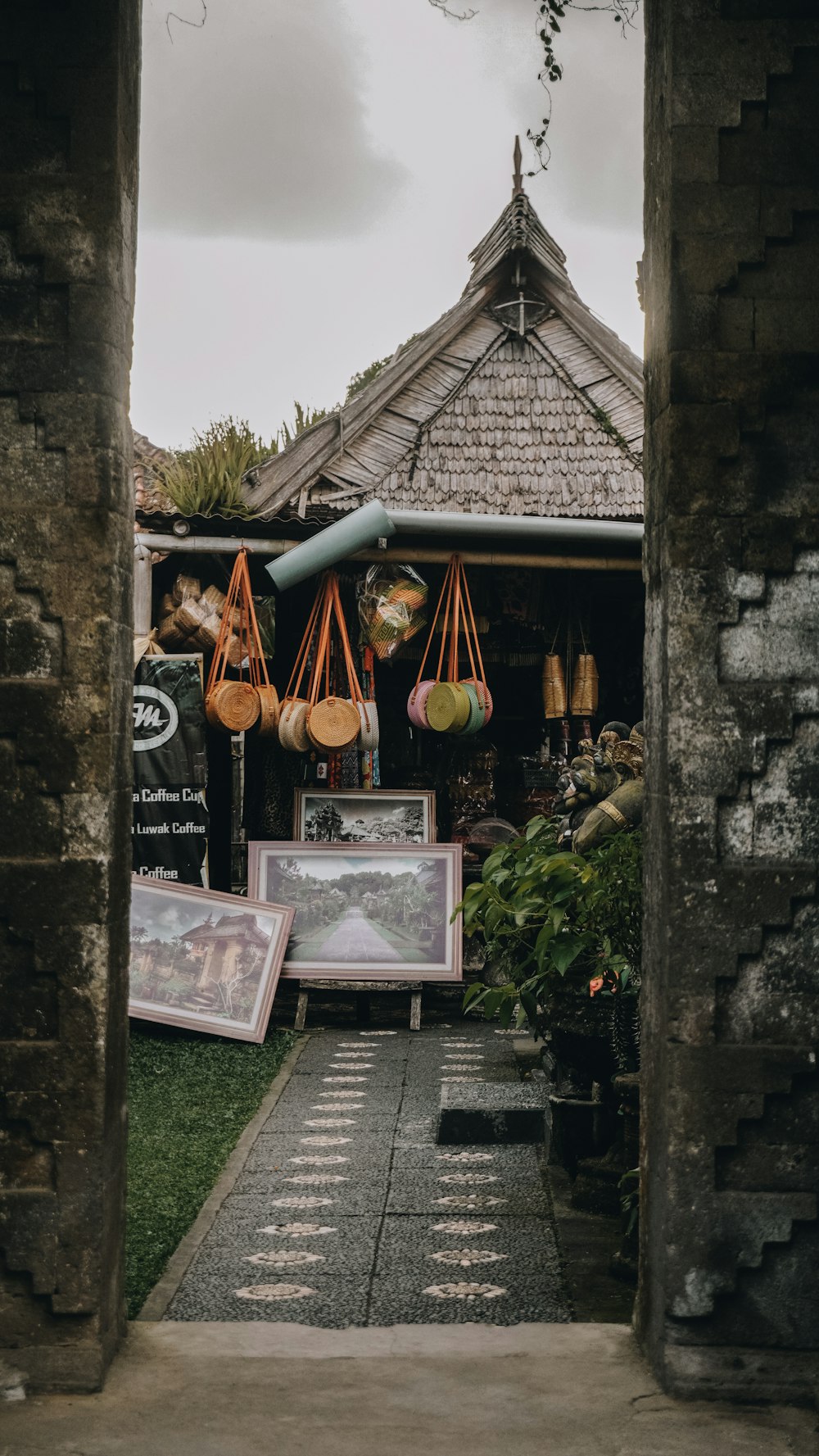 paitning and collectibles on yard near brown house under grey cloudy sky