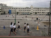 Children participating enthusiastically in an outdoor sports activity on the school playground.