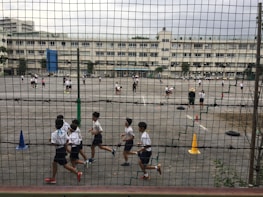 Children participating enthusiastically in an outdoor sports activity on the school playground.