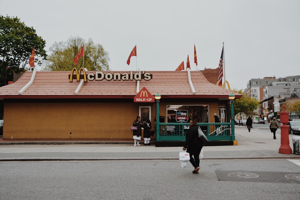 mulher caminhando em direção à filial do McDonald's durante o dia