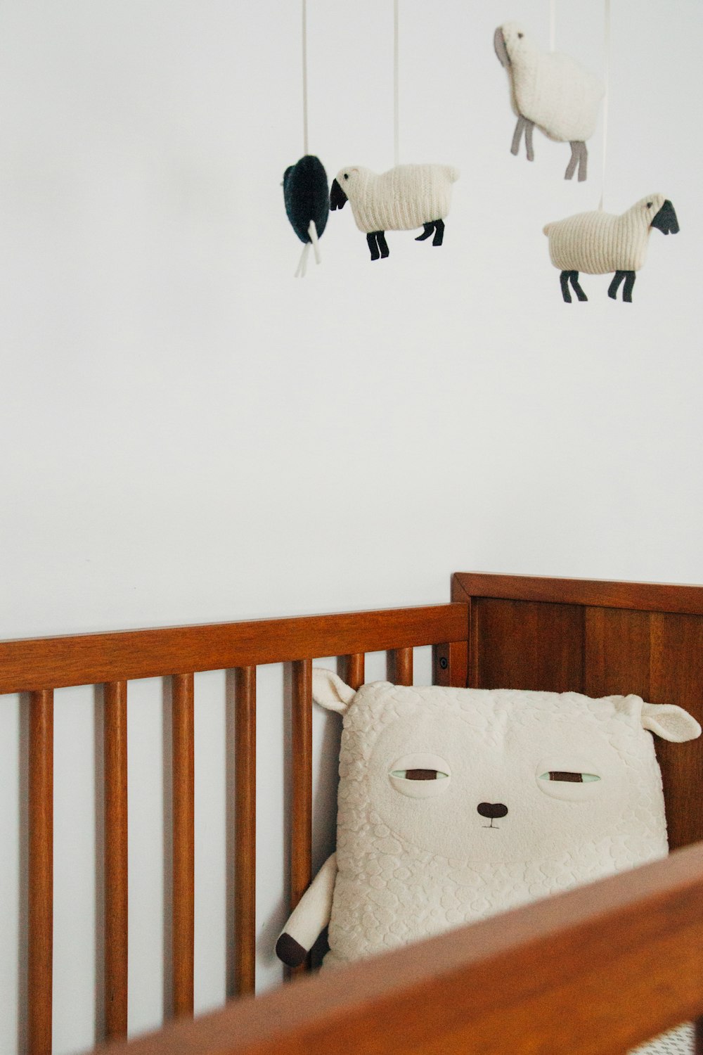 양 베개와 유아용 침대 모빌이 있는 유아용 침대
