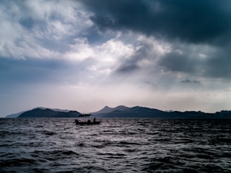 silhouette of person sailing boat during daytime