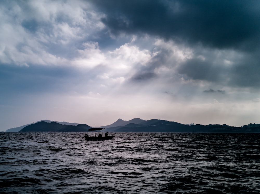 silhouette of person sailing boat during daytime