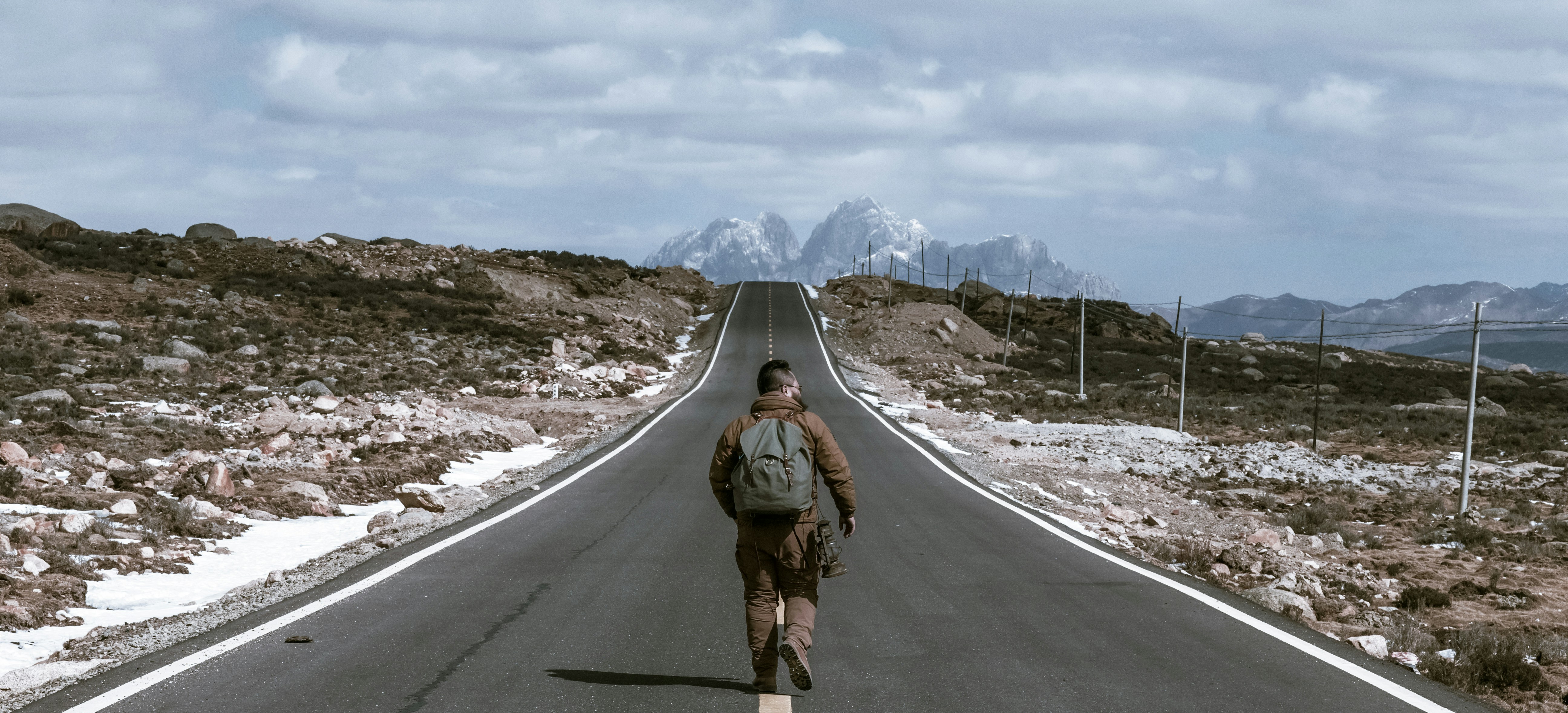 energized man walking on the center of road during daytime