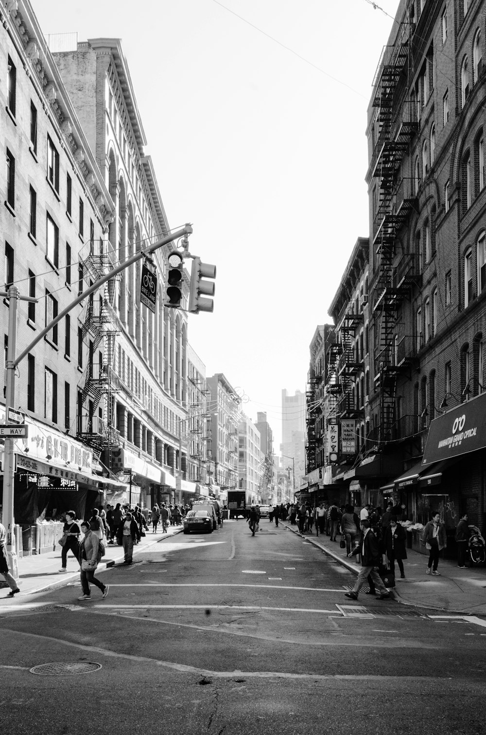 grayscale photo of people walking on sidewalk